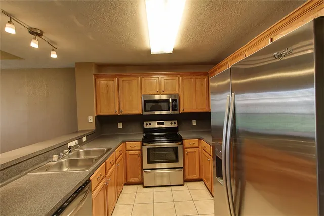 a kitchen with stainless steel appliances granite countertop a refrigerator and a stove