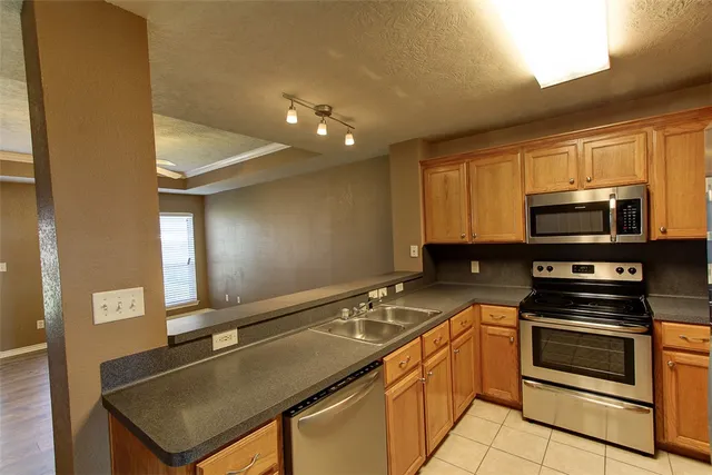 a kitchen with stainless steel appliances a stove a microwave and a sink