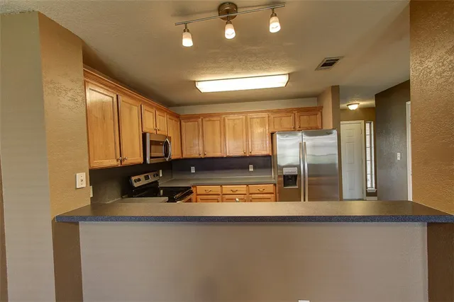 a kitchen with stainless steel appliances granite countertop a sink refrigerator and cabinets