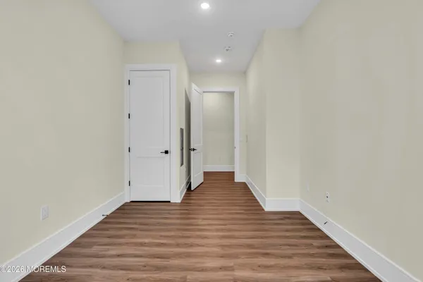 a view of a hallway with wooden floor