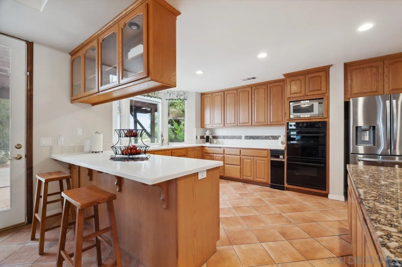 15091 Chemise Creek Road Ramona, CA 92065 - Photo 51 of 74 a kitchen with stainless steel appliances granite countertop a refrigerator and a stove top oven