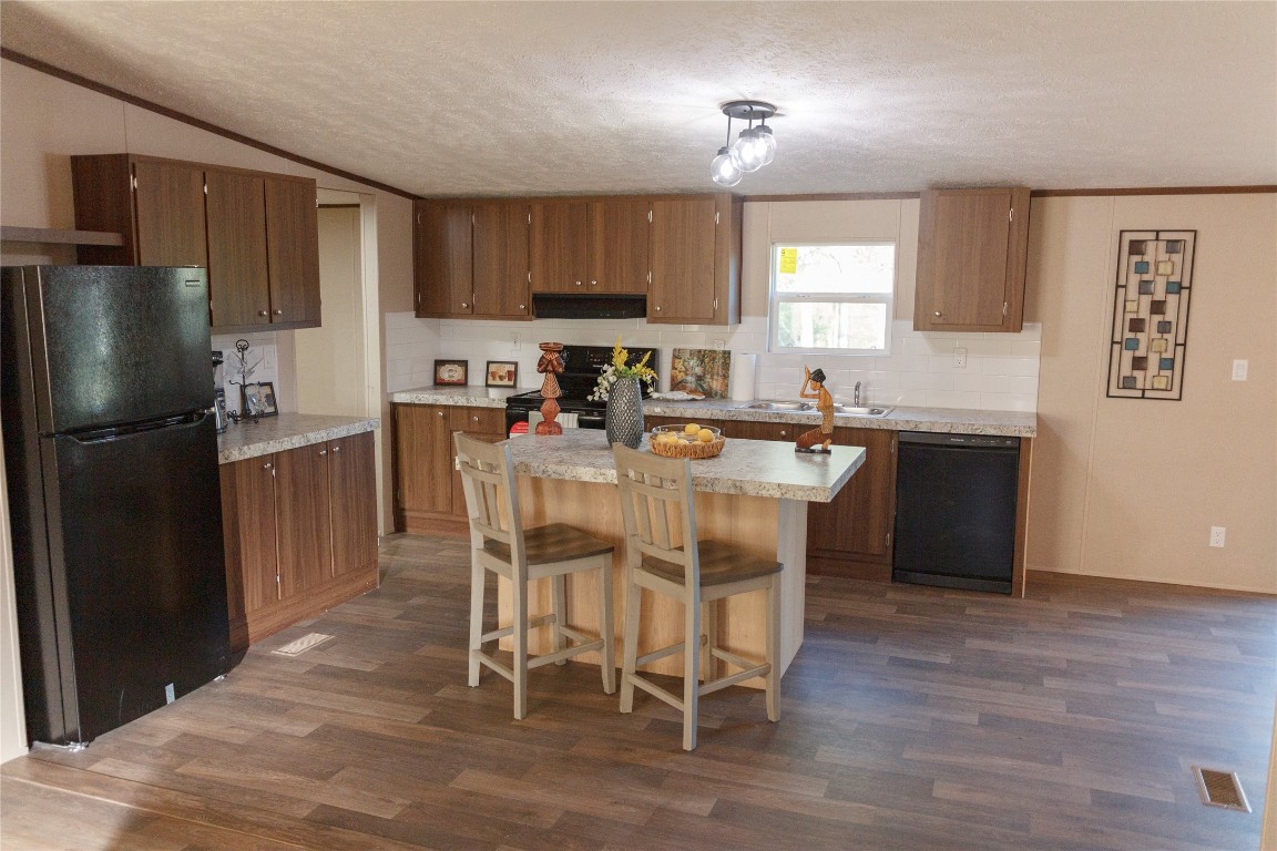 1977 Jeddo Road Rosanky, TX 78953 - Photo 6 of 30 a kitchen with stainless steel appliances granite countertop a stove a refrigerator a sink a dining table and chairs