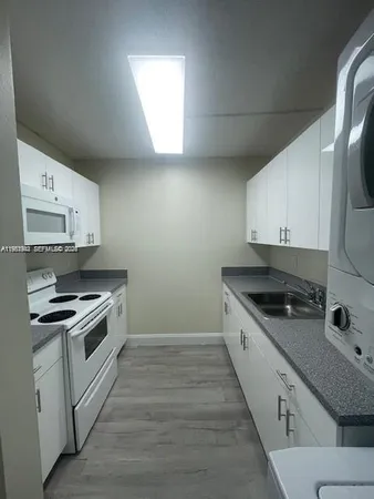 a kitchen with granite countertop a stove and a sink