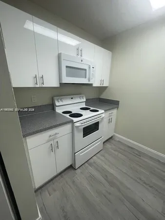 a kitchen with granite countertop a stove and a sink