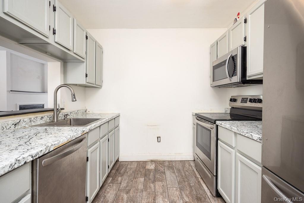 1406 Eagles Ridge Road Brewster, NY 10509 - Photo 9 of 23 a kitchen with stainless steel appliances granite countertop a sink stove and microwave