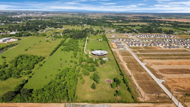 an aerial view of a residential houses with outdoor space and a lake view