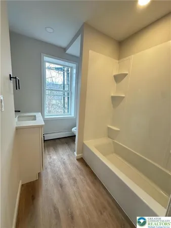 a bathroom with a tub sink and a window