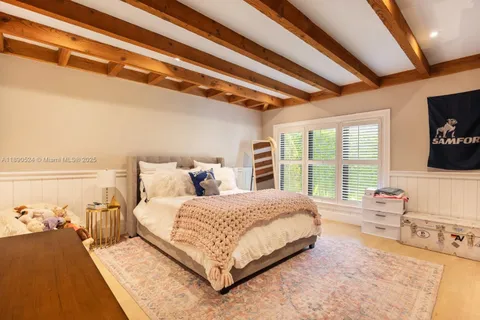 a bedroom with a bed a couch and large window