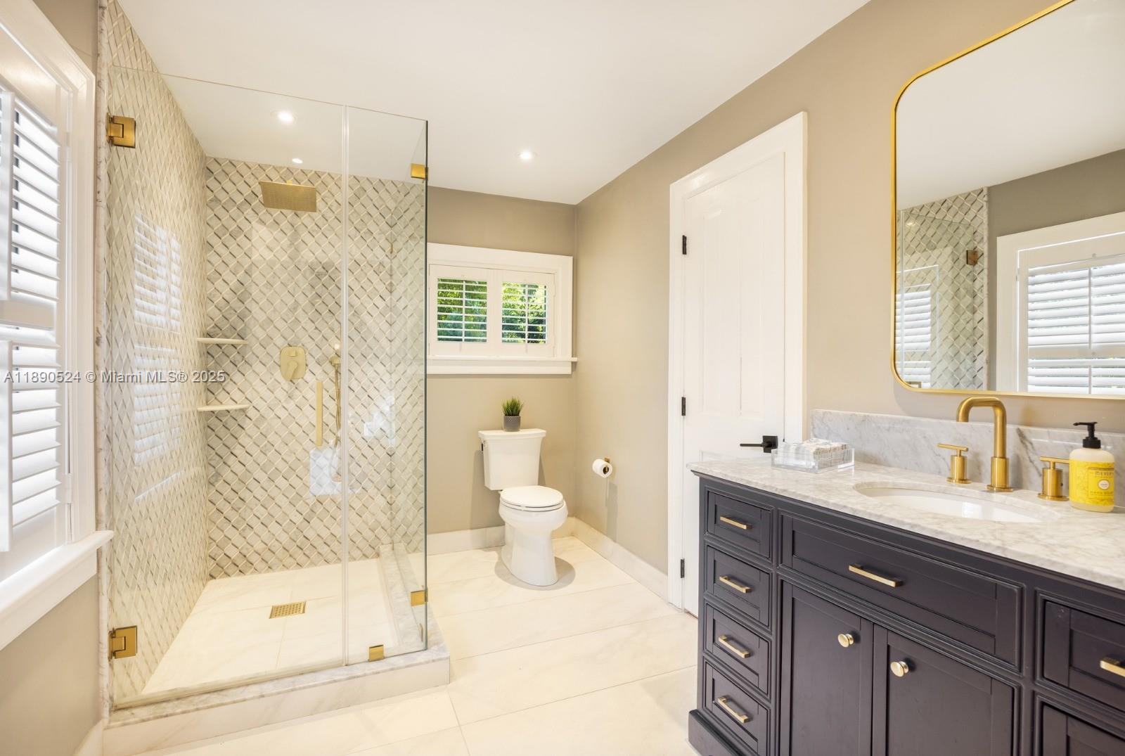 8521 Southwest 145th Street Palmetto Bay, FL 33158 - Photo 17 of 27 a bathroom with a double vanity sink toilet and shower