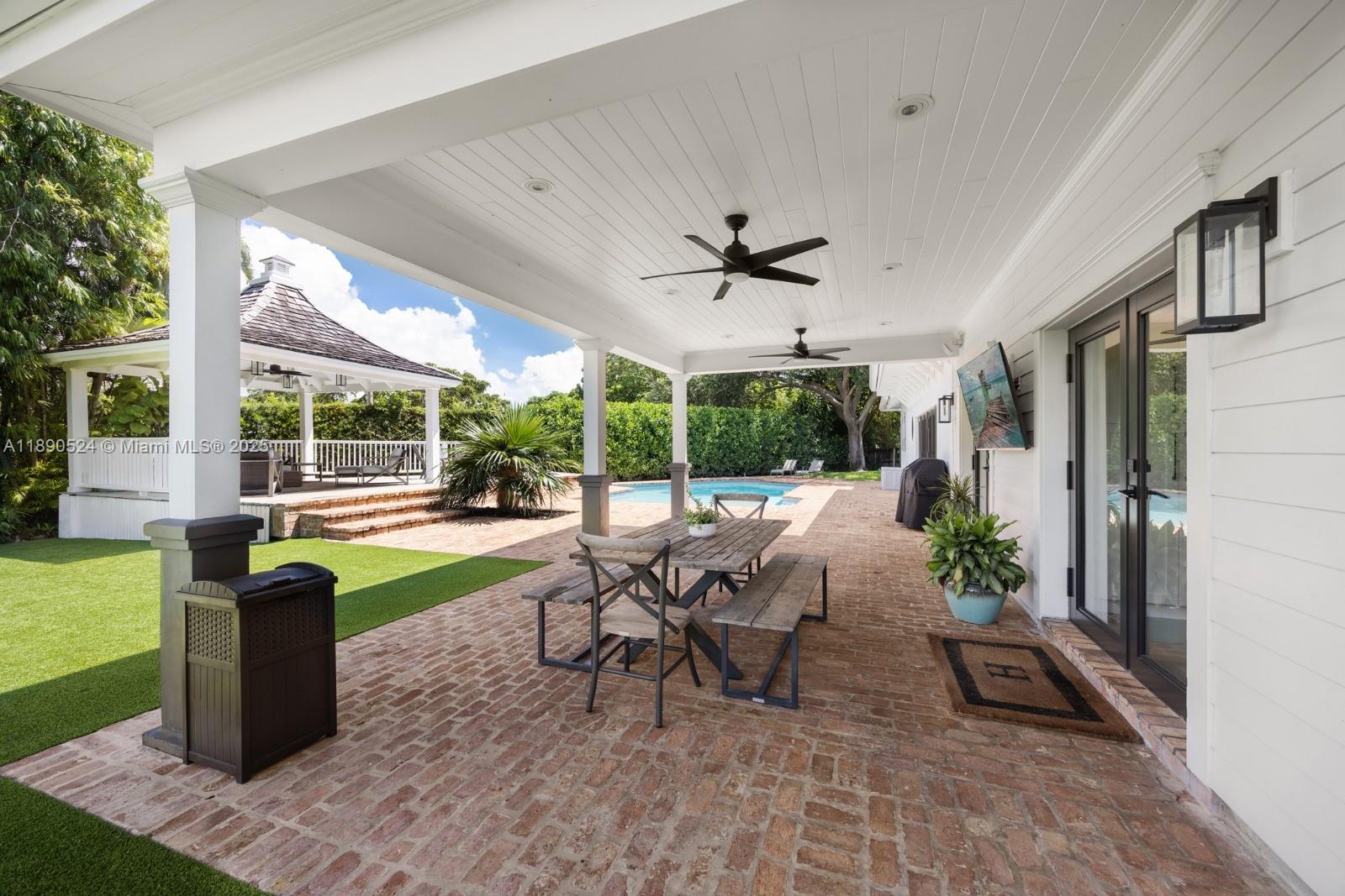 8521 Southwest 145th Street Palmetto Bay, FL 33158 - Photo 21 of 27 a view of a patio with table and chairs potted plants with floor to ceiling window