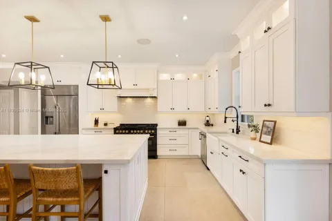 a kitchen with stainless steel appliances granite countertop a sink a stove and a wooden floors