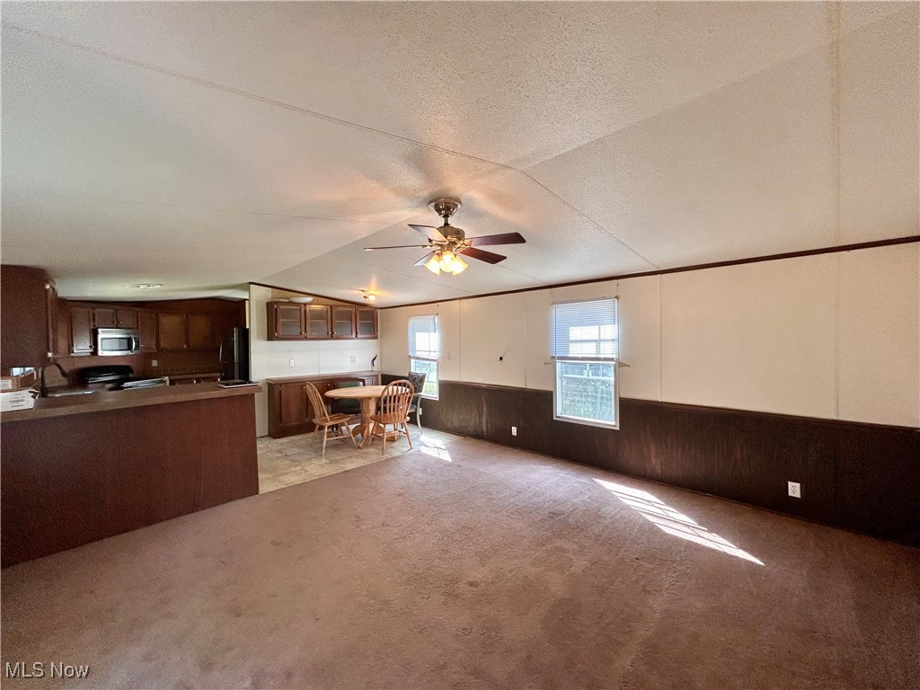 84550 Snyder Road Jewett, OH 43986 - Photo 8 of 21 Kitchen featuring a wainscoted wall, light colored carpet, fridge, ceiling fan, and stainless steel microwave