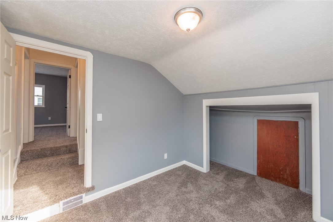 3880 Strandhill Road Cleveland, OH 44128 - Photo 25 of 33 Bonus room with lofted ceiling, carpet floors, and a textured ceiling