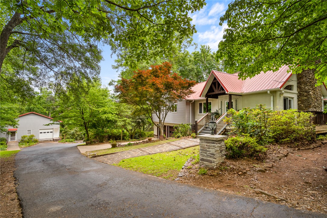 324 Hobson Road Anderson, SC 29621 - Photo 45 of 46 This secluded residence features a vibrant red roof and natural stone accents, nestled among lush greenery.
