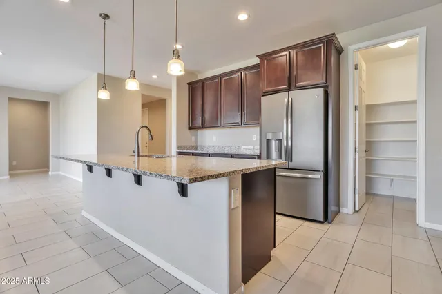 a open kitchen with stainless steel appliances granite countertop a refrigerator and a sink