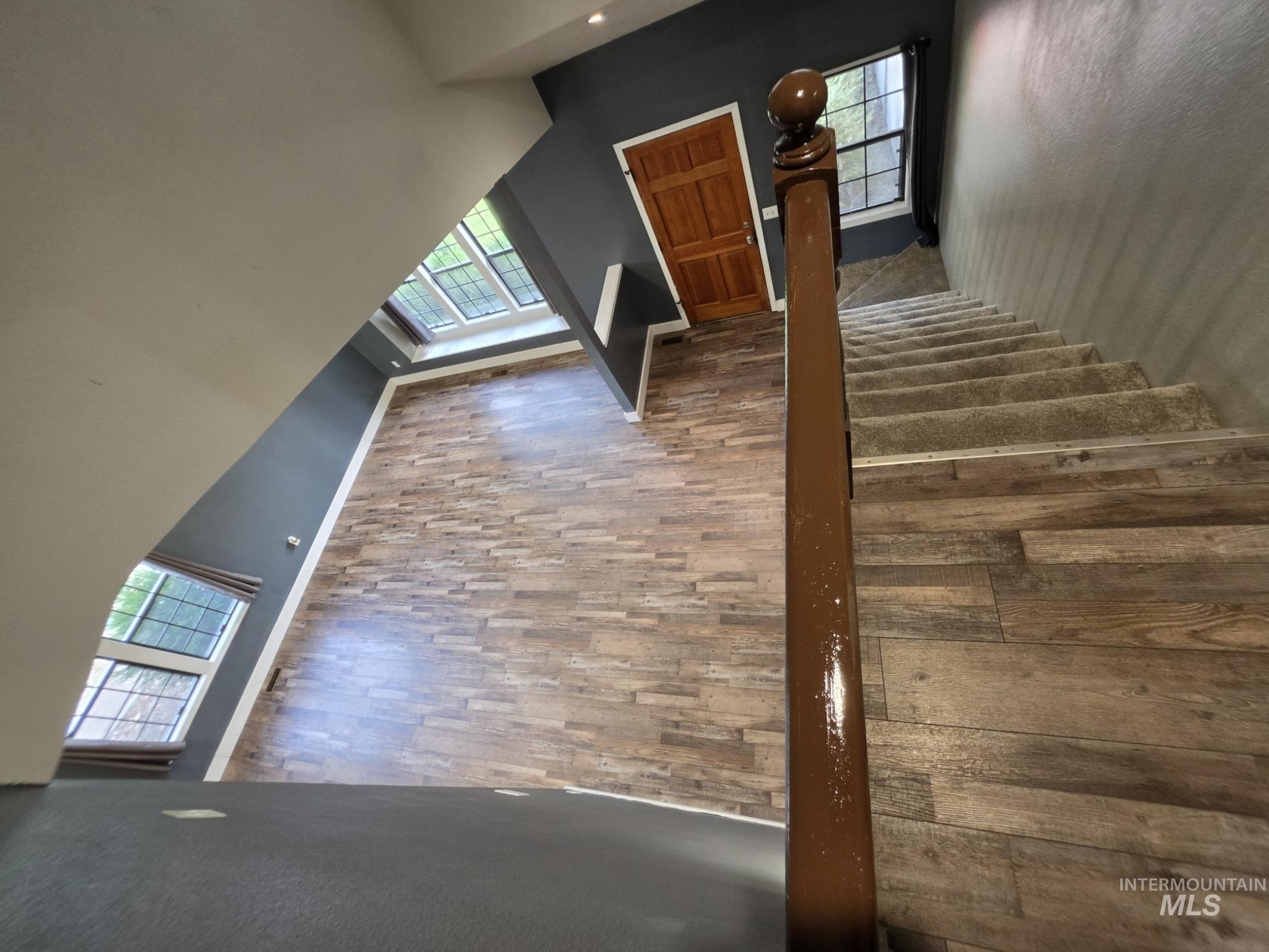 3201 South Riva Ridge Way Boise City, ID 83709 - Photo 18 of 29 Wood-finish flooring, staircase with carpeted treads, wood handrail, transom windows, and a paneled interior door