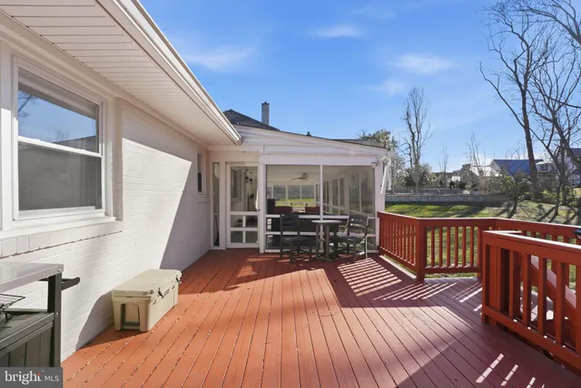 a view of a patio with couches chairs and wooden floor