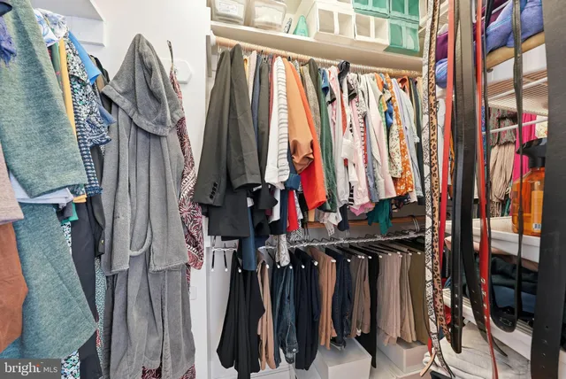 a view of walk in closet with clothes