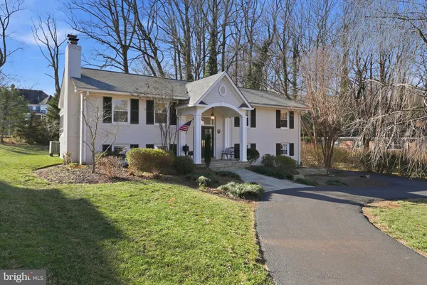 a front view of a house with a garden and trees