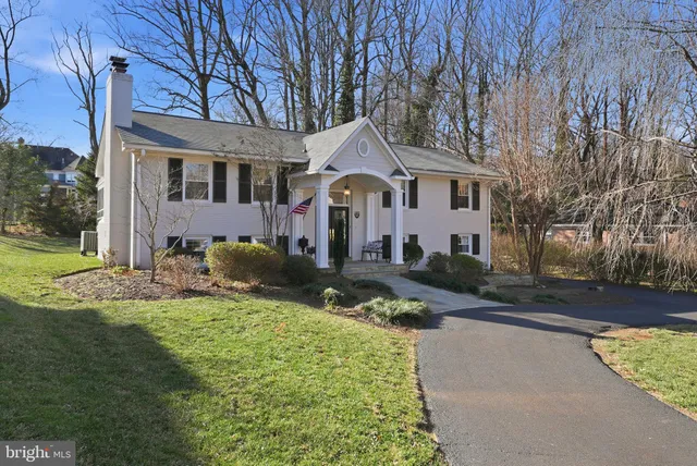 a front view of a house with a garden and trees