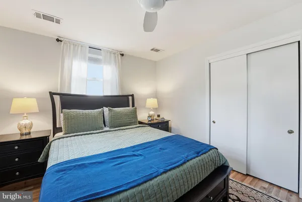 a bedroom with a bed and a lamp on dresser