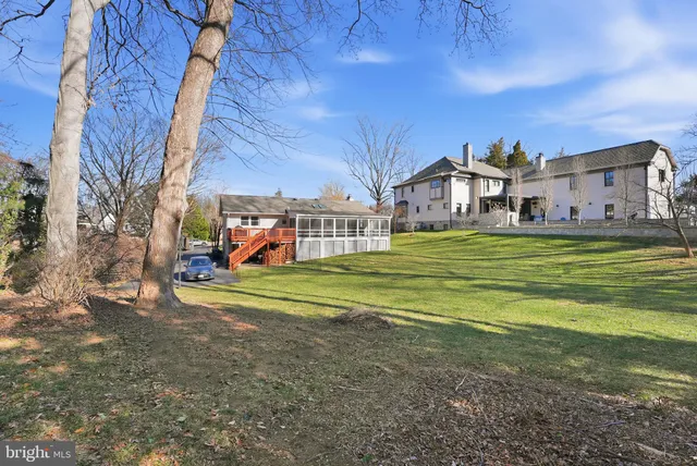 a view of a big house with a big yard and large trees