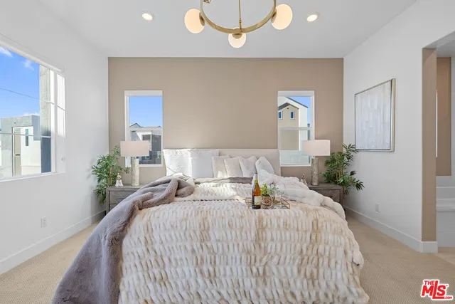 a spacious bedroom with a bed and a chandelier