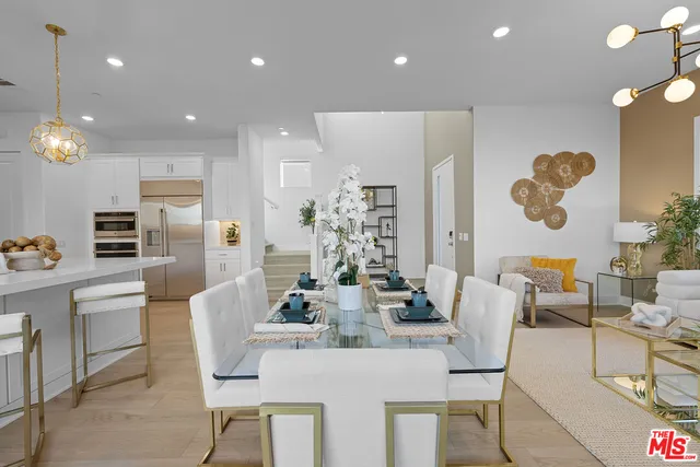 a dining hall with stainless steel appliances a dining table and chairs