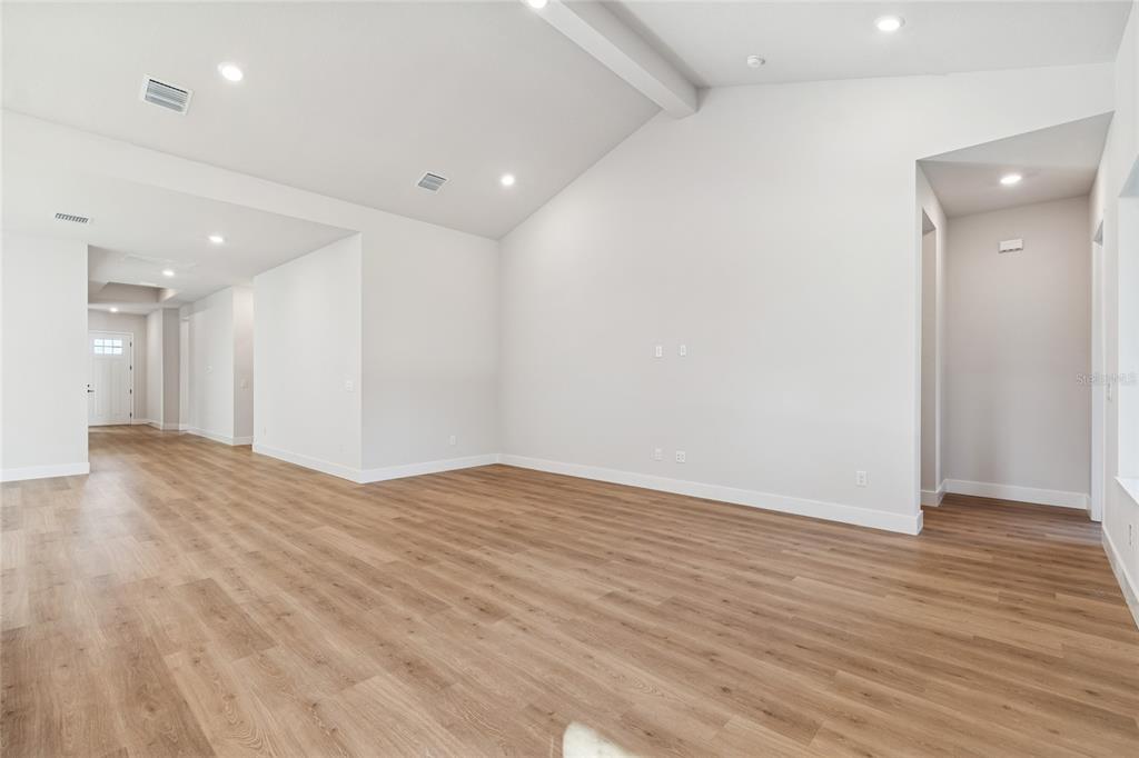 31479 Hayman Loop Wesley Chapel, FL 33545 - Photo 12 of 45 an empty room with wooden floor and bathroom view