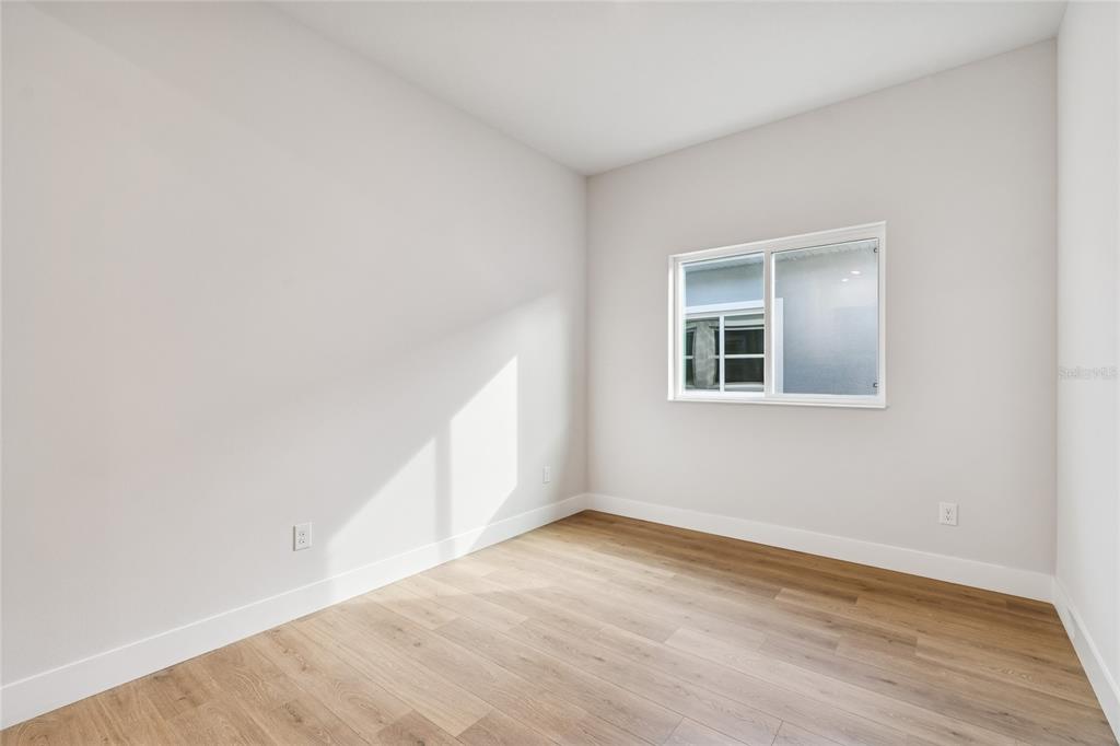 31479 Hayman Loop Wesley Chapel, FL 33545 - Photo 13 of 45 an empty room with wooden floor and windows