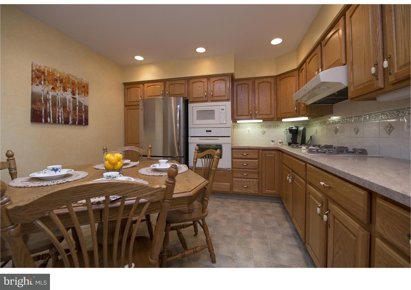 534 Kent Road Springfield, PA 19064 - Photo 11 of 24 a kitchen with stainless steel appliances granite countertop a sink a microwave a refrigerator and wooden cabinets