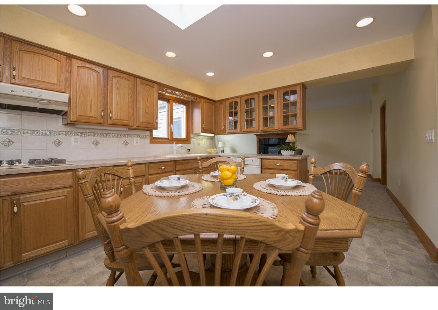 534 Kent Road Springfield, PA 19064 - Photo 10 of 24 a kitchen with stainless steel appliances kitchen island granite countertop a table chairs and a refrigerator