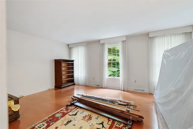 a view of an empty room with furniture and window
