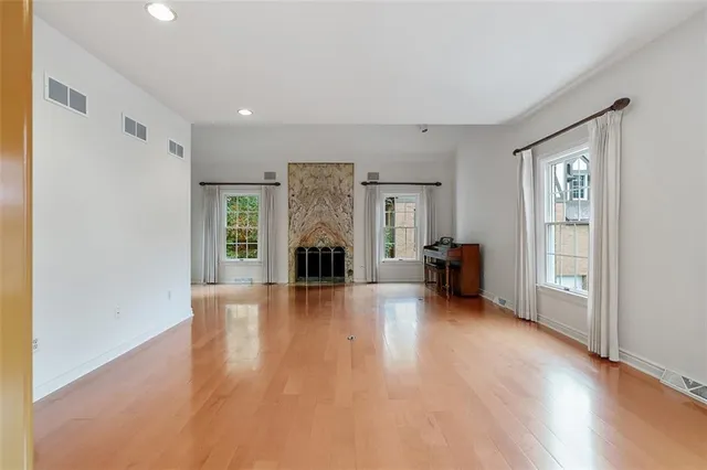 a view of empty room with wooden floor and fireplace