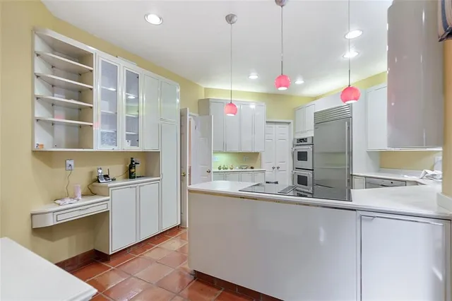 a kitchen with kitchen island a sink stainless steel appliances and cabinets