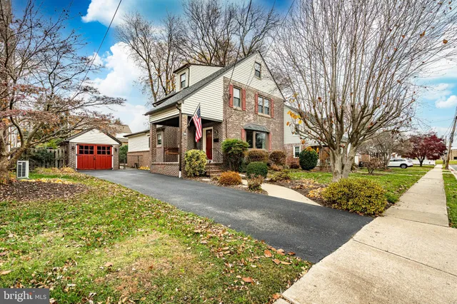 a front view of a building with large trees