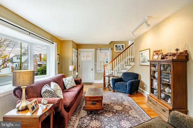 a living room with furniture a rug a lamp and a large window