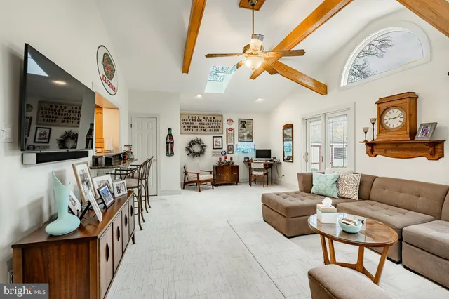a living room with furniture a flat screen tv and kitchen view