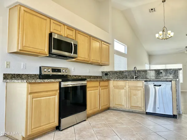 a kitchen with stainless steel appliances granite countertop a sink and a stove
