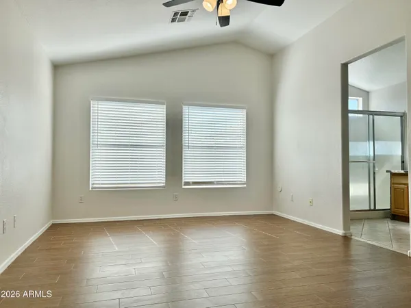 an empty room with wooden floor and windows