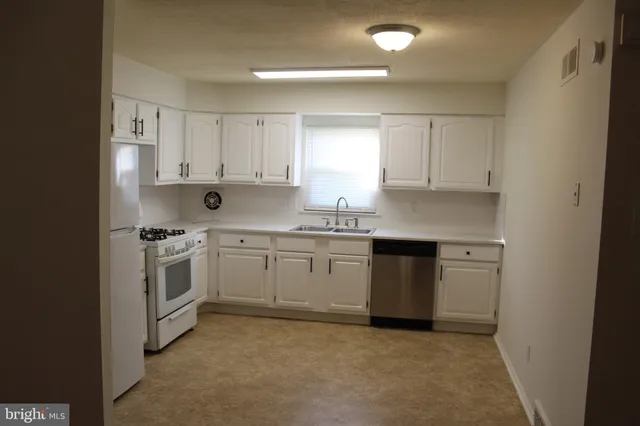 a kitchen with a white stove top oven and white cabinets