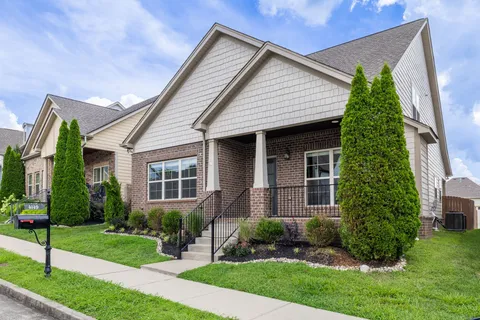 a front view of a house with a yard and potted plants