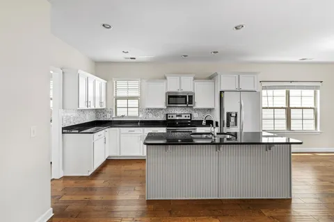 a kitchen that has a sink stainless steel appliances a counter space and a window