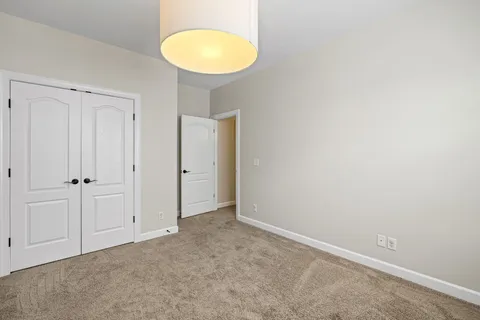 an empty room with closet and windows
