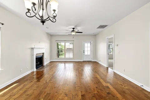 a view of a dining room with furniture a fireplace and wooden floor