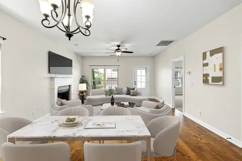 an empty room with wooden floor fireplace and windows