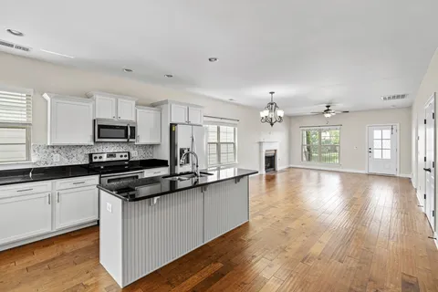 a kitchen that has a lot of cabinets a sink and appliances in it
