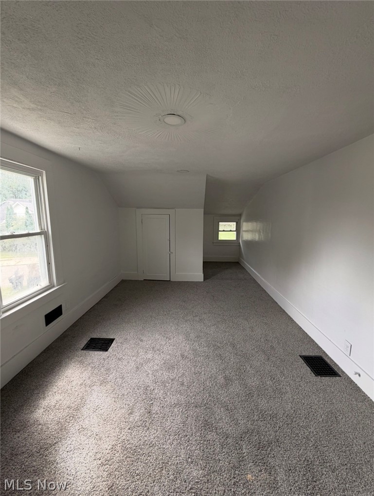 908 Palmyra Road Southwest Warren, OH 44485 - Photo 14 of 25 Expansive carpeted area with white walls, multiple windows, and a recessed ceiling light