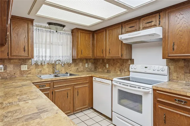 a kitchen with a sink stove top oven and cabinets