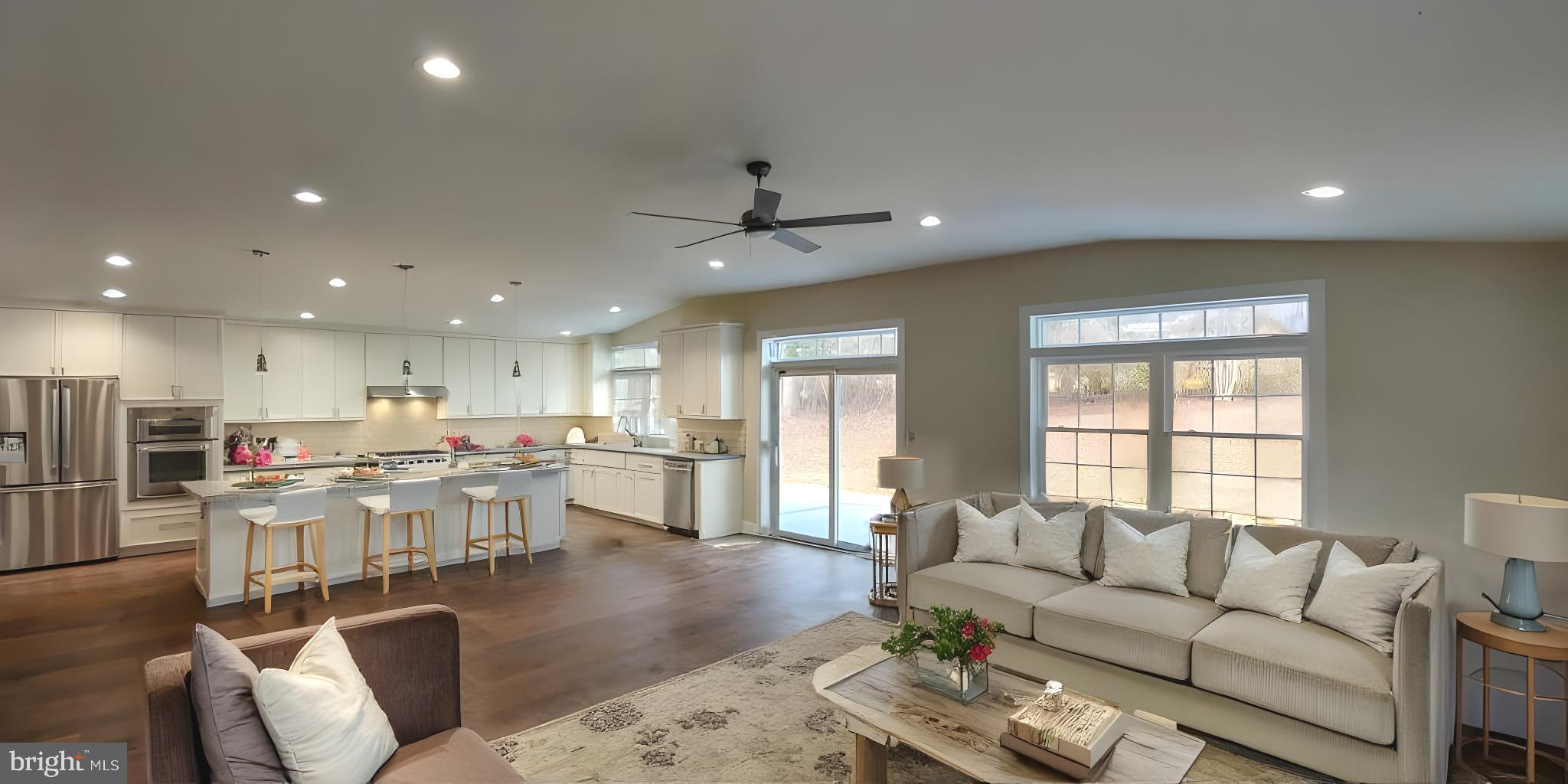 4909 Threadneedle Road Wilmington, DE 19807 - Photo 6 of 33 a living room with furniture a rug kitchen view and a large window